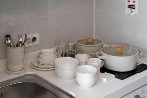 釜山Urbanstay Seomyeon的厨房柜台,配有白锅、平底锅和盘子