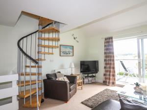 伊费林赫利Machlud Ynys的客厅设有螺旋楼梯和沙发