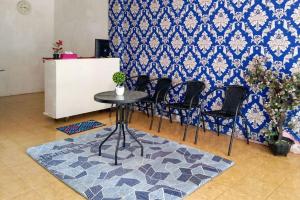 明古鲁省RedDoorz Syariah near Universitas Bengkulu的蓝色墙壁的房间里一张桌子和椅子