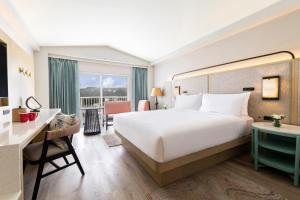 加拉班塞班岛皇冠假日度假酒店的酒店客房设有一张大床和一张书桌。