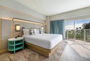 加拉班塞班岛皇冠假日度假酒店的一间带大床的卧室和一个阳台