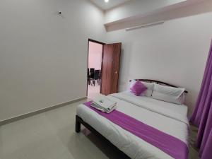 迈索尔Lishan Apartment的一间卧室配有一张大床和紫色窗帘