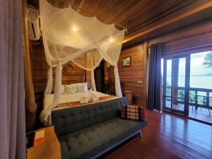瑶亚岛Esmeralda View Resort - SHA Extra Plus的一间卧室配有天蓬床和沙发