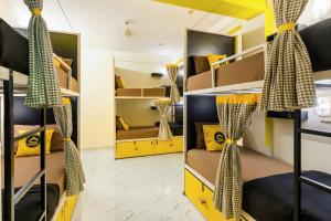 阿格拉The Hosteller Agra的宿舍间设有黄色和黑色的双层床