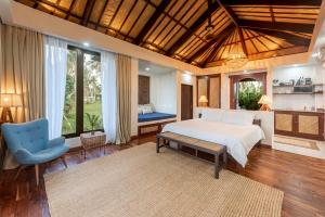 卢纳将军城VILLA JUAN - A Beach Front Villa in General Luna Siargao的一间卧室配有一张床和一张蓝色椅子