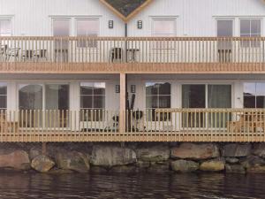 Dyrvik6 person holiday home in Kverva的水面上设有大甲板的房子