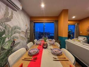 华欣La Habana Luxury 2 Bedroom Suites的一间带长桌和沙发的用餐室