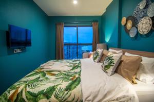 华欣La Habana Luxury 2 Bedroom Suites with Ocean View的一间卧室配有一张蓝色墙壁的床和一扇窗户