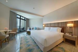 迪拜Arabian Park Dubai, an Edge by Rotana Hotel的一间带大床的卧室和一间客厅