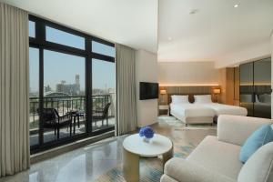 迪拜Arabian Park Dubai, an Edge by Rotana Hotel的酒店客房设有床和客厅。