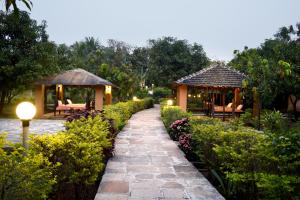 JambhulpādaSaffronStays Mango Huts by the River, Pali的花园内的走道,设有两个凉亭
