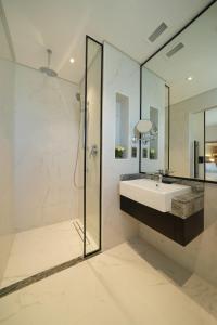 迪拜Arabian Park Dubai, an Edge by Rotana Hotel的白色的浴室设有水槽和淋浴。