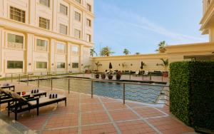 吉达Sunset Jeddah的一座带游泳池的建筑,前面设有长凳