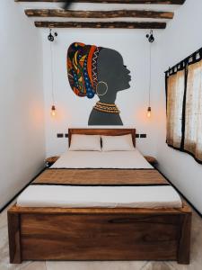 帕杰BaraBara Eat&Sleep - Eco Boutique Hotel的卧室配有一张带女性绘画的床