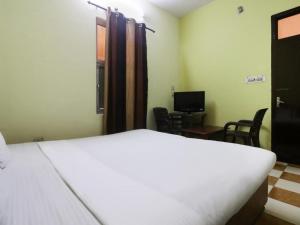 奈尼塔尔Goroomgo Blue Moon Resort Lake View Mall Road Bhimtal - Best Seller的一间带白色床的卧室和一间带椅子的房间