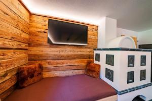 伊特尔Sonnentalhof的木墙上设有平面电视的房间