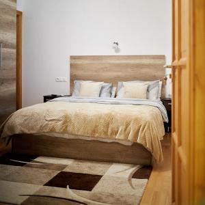 莫劳豪洛姆Klaudia Vendégház的一间卧室配有一张大床和木制床头板