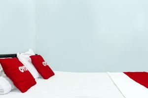 古邦OYO 91720 Hotel Yotowawa的一张带红色和白色枕头的床