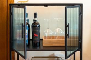 佛罗伦萨SPIRIT OF FLORENCE Boutique Rooms的一个带两瓶葡萄酒和眼镜的架子