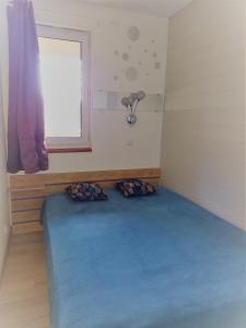 瓦尔卢龙Charmant logement sur la station de Val Louron的一间设有蓝色床的房间,房间设有窗户