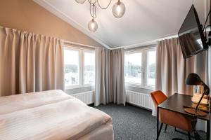 塔林Rija Fonnental Design Hotel Tallinn的酒店客房设有一张床、一张书桌和窗户。