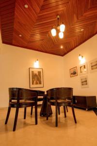 吉塞尼Elevate Suites Gisenyi的天花板的房间设有两把椅子和一张桌子