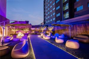 波尔图HF菲尼克斯波尔图酒店的一个带紫色和白色椅子及遮阳伞的庭院
