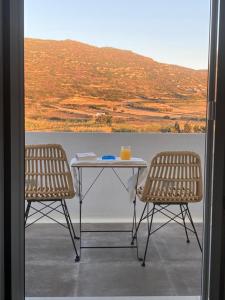 纳克索乔拉Ninemia Naxos Suites的阳台配有一张桌子和两把椅子