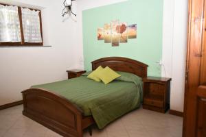 卢里西亚Le casette nel verde的一间卧室配有一张带绿色棉被的床