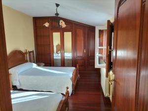 艾斯特拉达Casa Rural A Telleira的一间卧室设有两张床和一个带镜子的门
