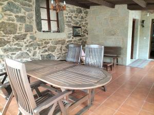 艾斯特拉达Casa Rural A Telleira的木桌和椅子,石墙