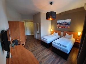 格赖茨Hotel Friedensbruecke的酒店客房设有两张床和一张桌子。