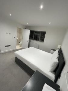 伦敦London West Ham Apartments的卧室配有一张白色的大床和一张沙发。