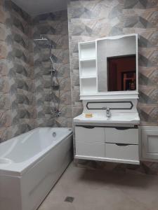 巴库My sweet home in Qara Qarayev的带浴缸、水槽和镜子的浴室