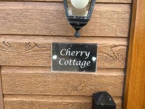 约克Cherry Cabin with Hot Tub的木墙上写有樱桃小屋的标志