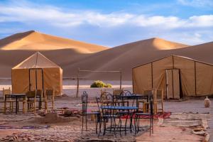 Foum ZguidBivouac Dune Iriki的沙漠中的一组桌子和帐篷