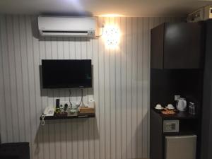 Juru7 Hotel的客房设有带电视和冰箱的墙壁。