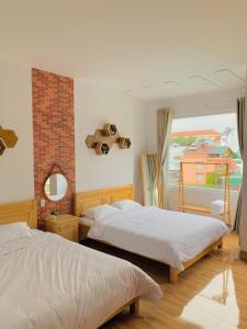 大叻Mi Casa Homestay的一间卧室设有两张床和窗户。