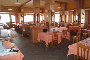 布勒伊-切尔维尼亚Hotel Breuil的餐厅配有桌椅和粉红色的桌布