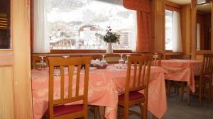 布勒伊-切尔维尼亚Hotel Breuil的用餐室配有带粉红色桌布的桌子