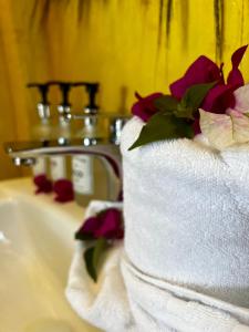 江比阿Equalia Rose hotel的浴室水槽上方的带鲜花的毛巾