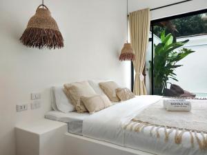 爱妮岛Bahala Na Villas的窗户客房内的一张白色床