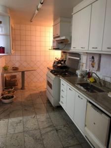 瓜拉派瑞Amplo apartamento em Guarapari com vistas pro mar的厨房配有白色橱柜和炉灶烤箱。