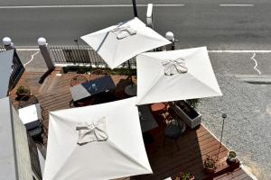 西尔米奥奈玛诺达酒店的庭院里的一组白色遮阳伞