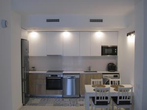比利亚努埃瓦-赫尔特鲁Family Apartment的厨房配有白色橱柜和桌椅