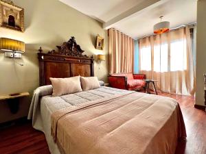 托莱多阿尔穆尼亚德善秘古尔酒店的一间卧室配有一张大床和一把椅子