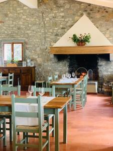 基安蒂格雷夫Albergo Villa San Michele的一间设有木桌和椅子的餐厅以及石墙
