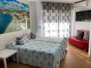 阿尔姆尼卡Apartamentos sol y playa Almuñécar的一间卧室设有一张床和一个大窗户