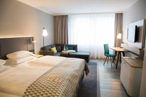 诺伊斯Holiday Inn Düsseldorf-Neuss, an IHG Hotel的酒店客房设有床和客厅。