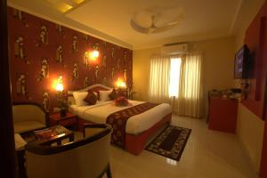 班加罗尔Royal shades kodihali的配有一张床和一把椅子的酒店客房